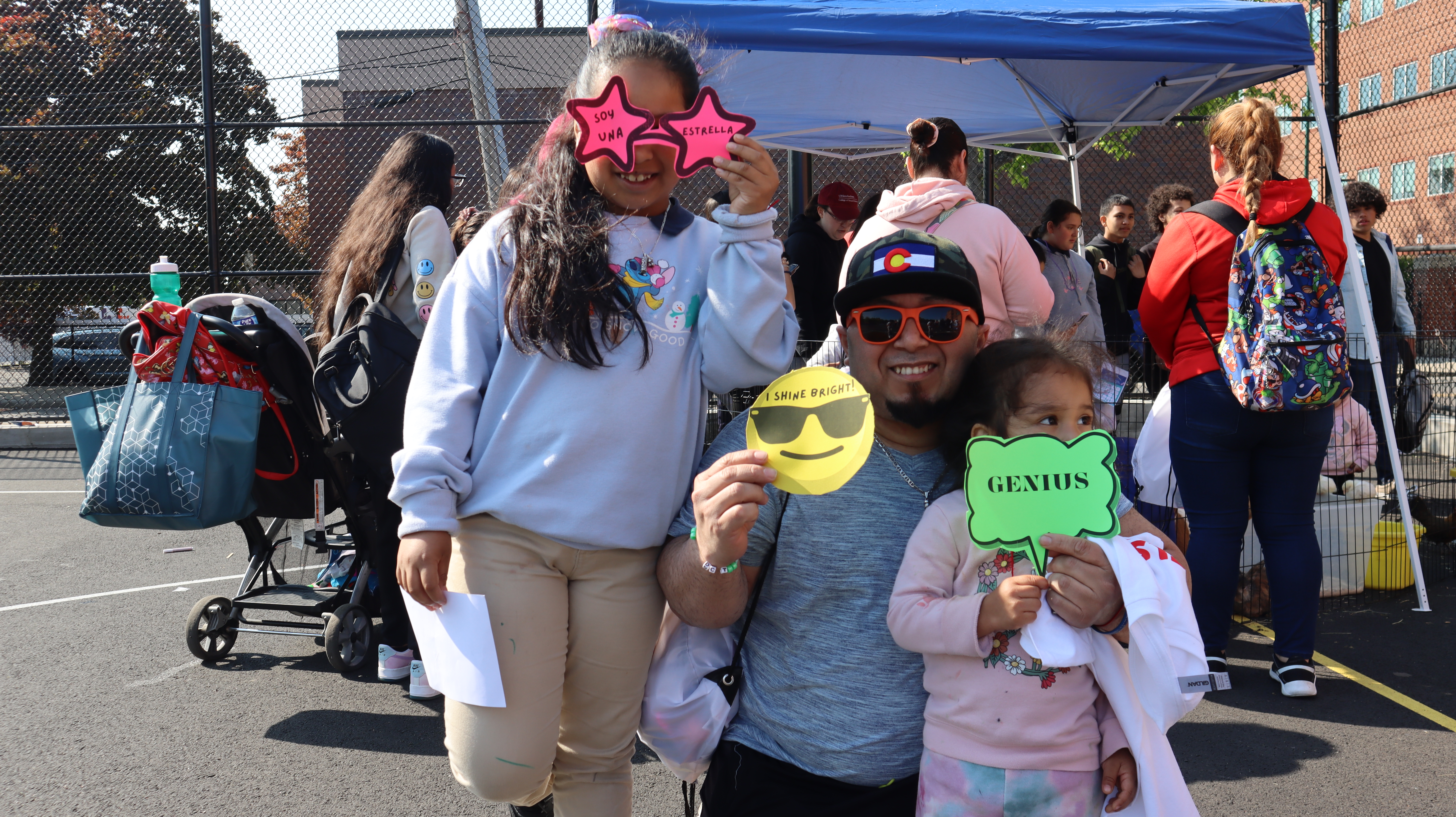 A father and two children pose for a photo at Chelsea's Youth Mental Health Day.